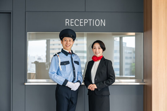 受付に立つ警備員とスタッフ。ホテル、ホテリエ、警備、セキュリティ、防犯、安全、仕事、施設、案内、企業