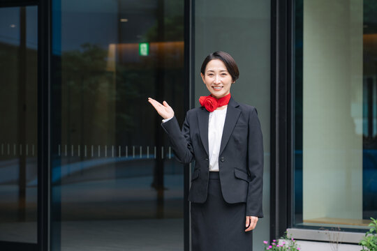 案内する女性スタッフ。受付、ホテル、ホテリエ、誘導、イベント、百貨店、デパート、日本人、歓迎、出迎え