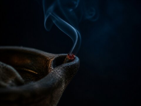 Smoking candle wick in darkness. Dramatic metaphor for spiritual readiness, warning, mortality, faith, and the biblical parable of wise and foolish virgins.