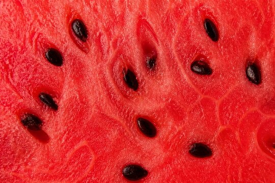 Watermelon flesh with black seeds closeup food background