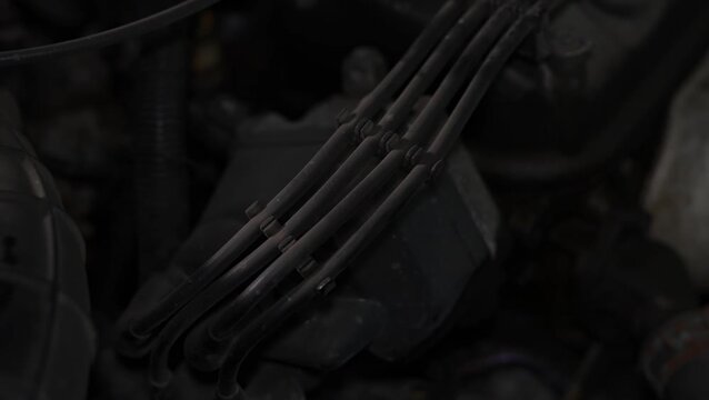 Car engine bay with high voltage ignition spark plug wires.