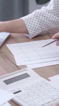 Office worker balancing budget with calculator and laptop on a desk. Bookkeeping, finance audit and taxes