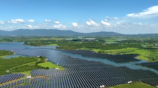 Aerial view of floating solar power station on water surface under blue sky
