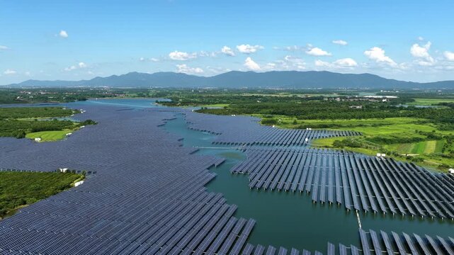 aerial view of floating solar power station on water surface with mountains in background