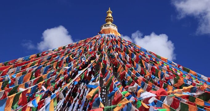 The Changqing Chunker Temple in Litang, China. Many colourful prayer flags on the mountain top beside the temple.Spirituality and meditation.	