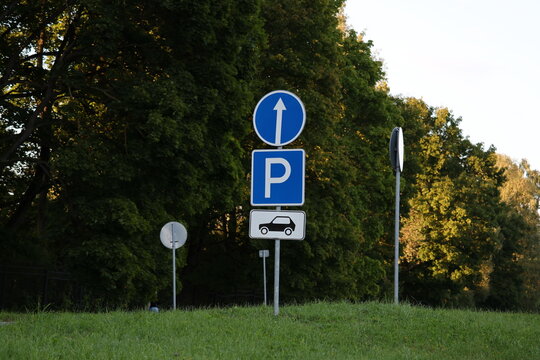 Road signs indicating straight ahead travel and designated parking for specific vehicles, urban traffic regulation