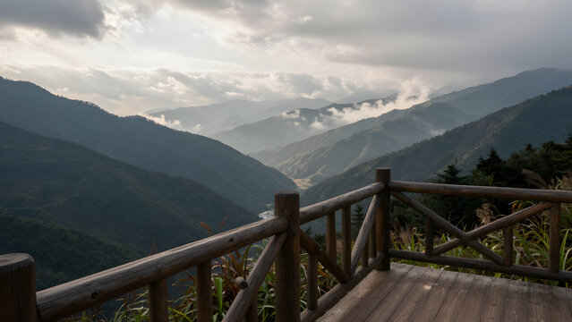 Wooden railing on a scenic mountain viewpoint overlooking a misty valley.