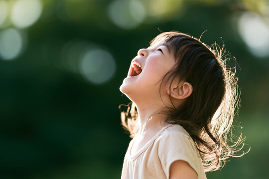 自然の中で空に向かって大声を出して叫んでいる4歳・5歳の日本人の女の子
