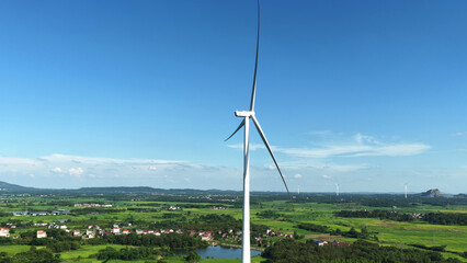 Wind turbine standing in green rural landscape under blue sky © zhangyang135769