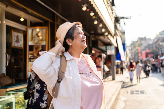 Asian senior woman traveler traveling and exploring the city outdoors. 