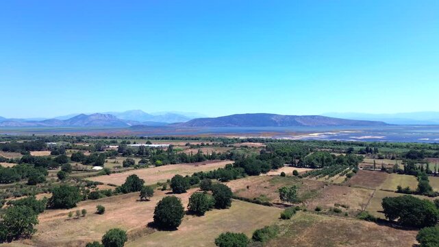 Lateral horizontal camera movement as a drone flies sideways revealing the beautiful green fields and waters of Tsopeli Lagoon near Preveza.