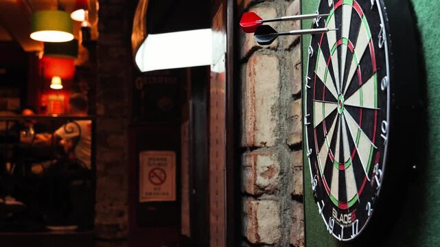 Close-up of a dartboard in a pub as darts are thrown at the target. High quality 4k footage
