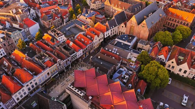 Golden-hour aerial of Zwolle, Netherlands, showing dense historic rooftops, narrow streets and a distinctive modern roof structure within the old city center.