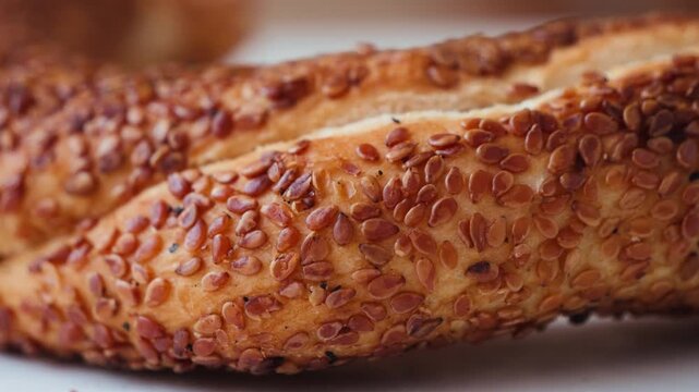 Close-up of Turkish simit bread covered with sesame seeds, served on a plate. Traditional Turkish bakery food. High quality 4k footage