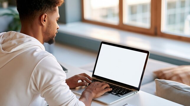 Person working on laptop seen from shoulder angle in bright room