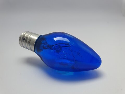 Close-up of a blue incandescent light bulb with a silver screw base, isolated on a white background.