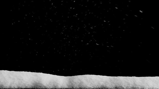 Snow falls on a wooden floor with a pile of snow