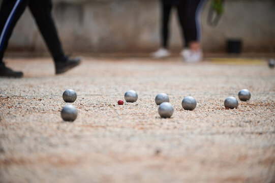 Petanque Boules and Red Cochonnet target Ball on Ground Outdoor Game