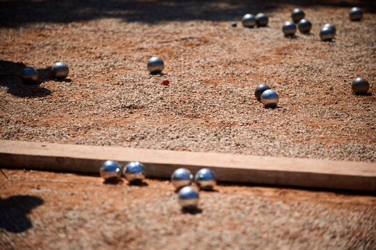 Multiple Petanque Boules Scattered on Gravel Court Outdoor Game Concept