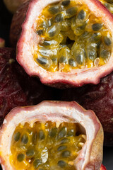 Obraz premium Close up of fresh halved passion fruit revealing juicy yellow seeds.