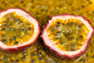 Obraz premium Fresh halved passion fruit with purple skin on bright yellow pulp backdrop