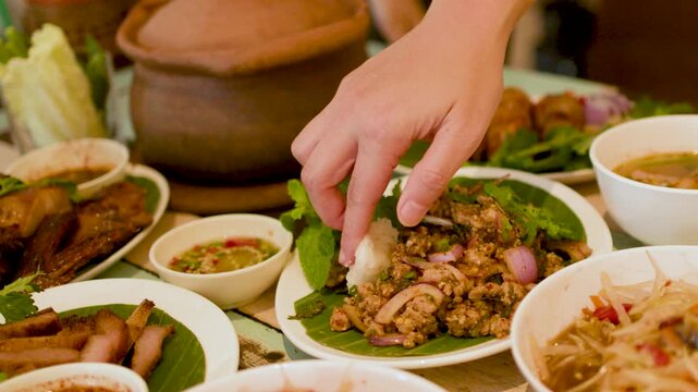 Person Eating Thai Isan Larb Moo Minced Pork Salad with Sticky Rice
