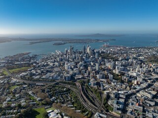 Fototapeta premium Stunning aerial view of Auckland CBD skyline, harbor, and motorways in Auckland, New Zealand, showcasing urban architecture on a sunny day.