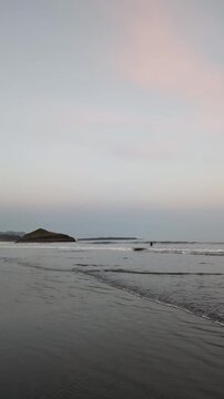 Tofino &mdash; a long beach with open-ocean waves set against a sunset; a great spot for surfing. Wide shot, real-time footage.