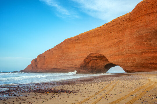 Red stone arch on Legzira beach in Morocco