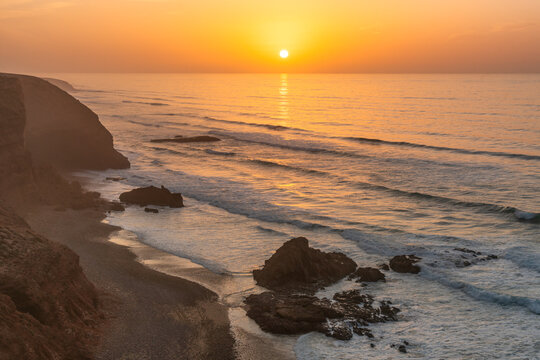Legzira beach coastline at sunset with ocean waves in Morocco