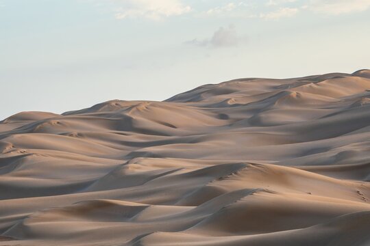 Golden light on rolling desert sand dunes in Sahara Morocco