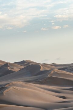 Soft light falls on rolling desert sand dunes in Sahara Morocco