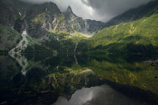 Morskie Oko lake reflects dramatic Tatra mountains under moody skies