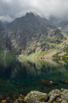 Misty mountain peaks reflected in a clear alpine lake in Zakopane