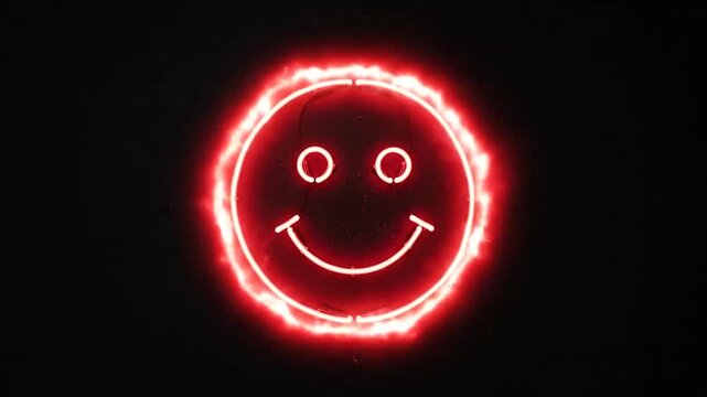 Red neon smiley face flickering on black background