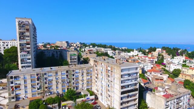 Aerial view of Vlora city with residential apartment buildings and blue sea horizon in Albania.