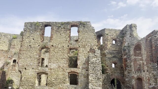 Old stone castle ruins with broken walls and windows under a bright cloudy sky. Zamek w Siewierzu  Poland, Siewierz, 5.08.2026  
