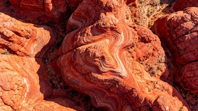 Aerial view of red sandstone formations with layered patterns in a desert landscape