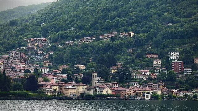 Lake Como, Moltrasio, Italy. Tranquil lake scene framed by green mountains and overcast skies after rain