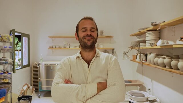 Proud small business owner posing in his pottery workshop