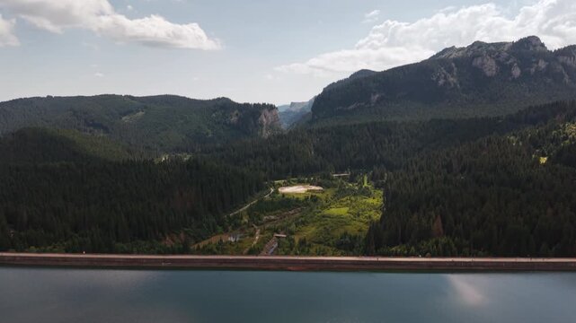 Long Bolboci Dam Wall Beneath Rocky Bucegi Peaks