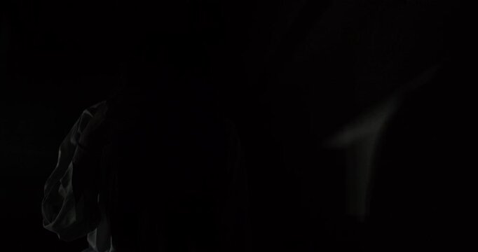 A terrifying female ghost emerges from the shadows of a dark, red-lit basement, creating a suspenseful and scary scene perfect for a Halloween horror movie trailer.