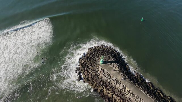 Drone aerial view starting over the Atlantic waves and moving towards Cabedelo Beach in Viana do Castelo, Portugal, on a bright sunny day.