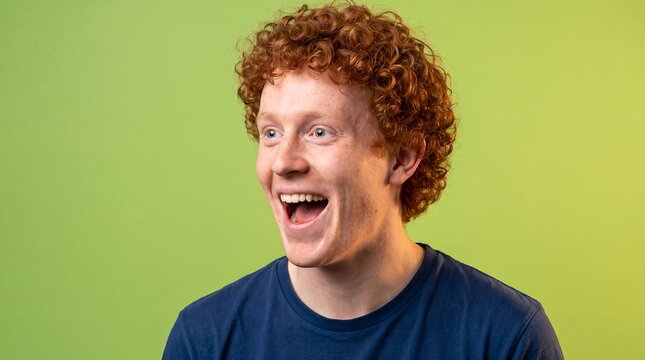 Young white man delighted surprise open mouth lime solid background A young White man shows an open mouth and wide eyes in delighted surprise for youth entertainment and exciting discovery campaigns