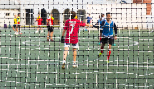 rear view of teenage goalie defending soccer net in game