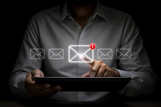 Person using tablet with glowing email notification icons and red alert symbol