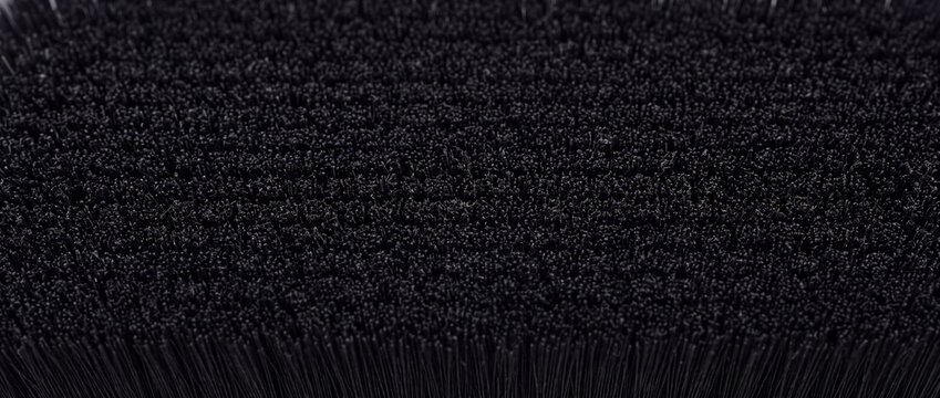Black synthetic brush bristles create dense textured surface for industrial or cleaning concepts.