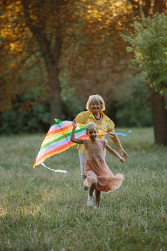 Grandmother and granddaughter flying kite in park