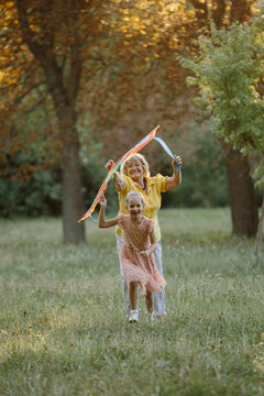 Grandmother and granddaughter playing with colorful kite in park