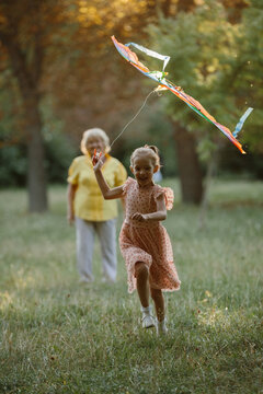 Granddaughter flying kite with grandmother in park